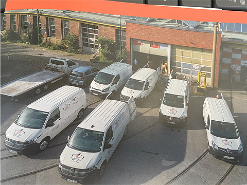 Die Lieferwagen sind alle vom selben Typ und sind in gutem Zustand. Sie sind alle weiß gestrichen und haben das gleiche Firmenlogo auf der Seite.